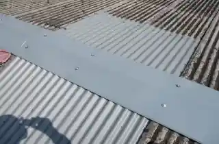 工場スレート屋根雨漏り修理後、傷んだ所を折板で部分カバー